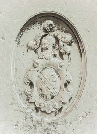 Old heraldic emblem relief with helm and shield on a Venice wallの写真素材