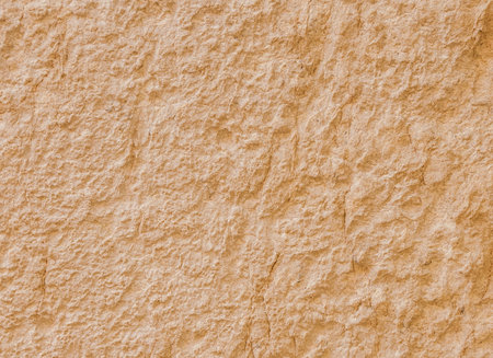 Yellowish rough old stone surface as background