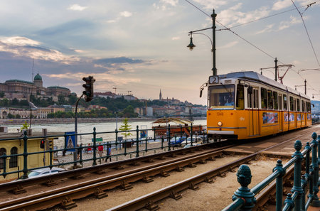 Budapest, Hungary, September 14, 2016: Public transport in Budapest. An old tram trundles along River Danube at sunsetのeditorial素材