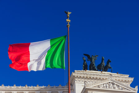Nationalism and sovereignty in Italy. 'Tricolore' Italian national flag fluttering in the wind before Altar of Nation monument, symbol of fatherlandのeditorial素材