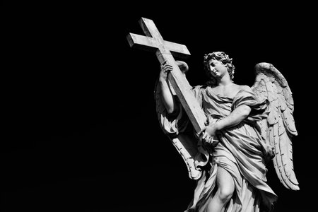 Angel statue holding Holy Cross. A 17th century baroque masterpiece at the top of Sant'Angelo Bridge in the center of Rome (Black and White with copy space)のeditorial素材