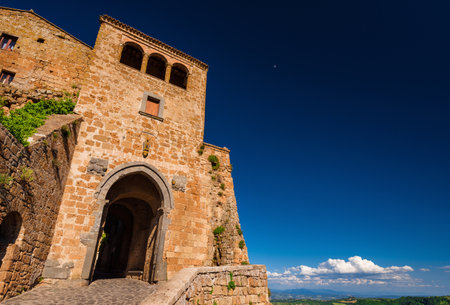 Civita di Bagnoregio "the town that is dying" medieval historic center ancient gate (with blue sky and copy space)のeditorial素材