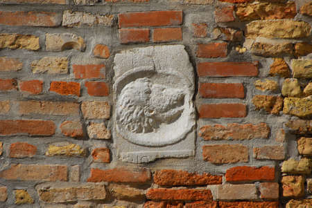 Ancient medieval relief of head with long hair and beard on a Venice wallの写真素材