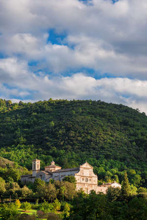 Scenic view of St Peter extra moenia ancient church in beautiful Spoleto countryside with clouds above and sunset lightの写真素材