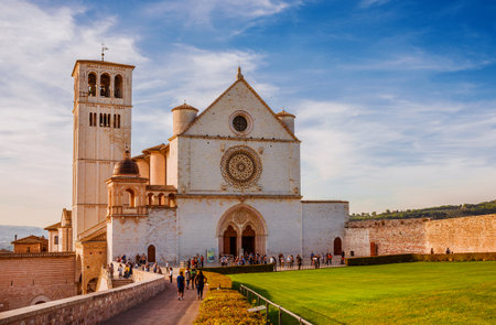 Tourists visit the famous Basilica of Saint Francis of Assisi in Umbria at sunsetのeditorial素材