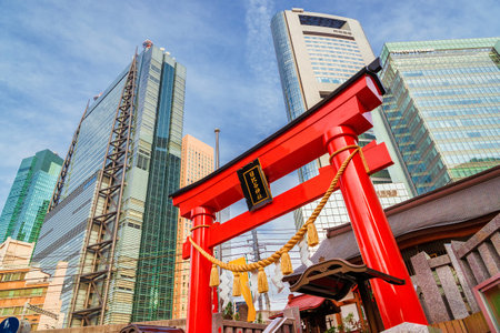 Tradition and Modernity in Japan. View of Shimbashi-Shiodome modern skyscrapers behind the red gate of Hibiya Shrine in downtownのeditorial素材