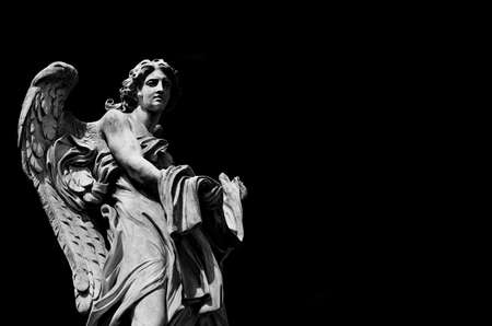 Angel marble statue with garment and dice, a 17th century baroque masterpiece on Holy Angel Bridge in Rome (Black and White with copy space)