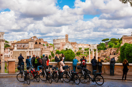 Cyclotourism in Rome. Tourists visit the city beautiful  historic center with Roman Forum ancient ruinsのeditorial素材