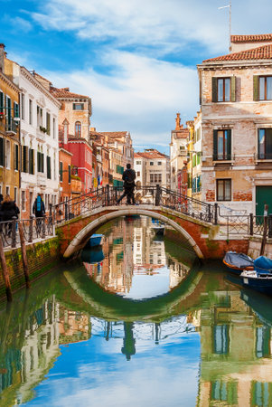 View of Rio Marin canal with its colorful houses and tourists in Venice historic centerのeditorial素材