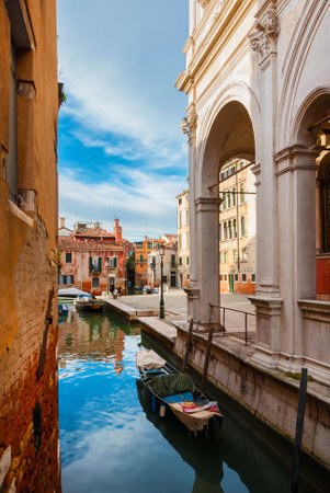 View of Rio della Frescada canal and Castelfrote area with its colorful houses just behind the famous Scuola Grande di San Rocco (Great School of St Roch) in Veniceのeditorial素材