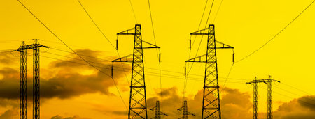 Electric power industry. Transmission towers or electricity pylons with golden sky