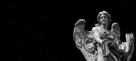 Angel statue holding the garment and dice of Jesus Passion. A 17th century baroque masterpiece at the top of Sant'Angelo Bridge in the center of Rome (Black and White with copy space)の写真素材