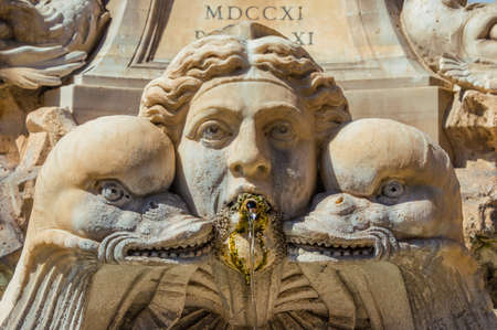 Baroque art in Rome. Marble mask among dolphins or fish from 18th century Fountain of the Pantheonの写真素材