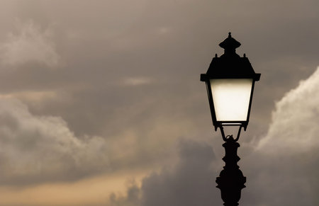 Old fashioned street lamp against cloudy sky (with copy space)の写真素材