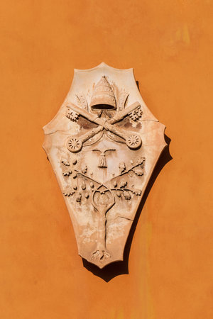 Old ecclesiastical emblem of cardinal or bishop on a wall in Lucca
