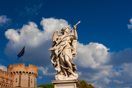 Angel holding the Holy Lance of Longinus with beautiful clouds. A 17th century baroque masterpiece at the top of Sant'Angelo Bridge in the center of Romeの写真素材