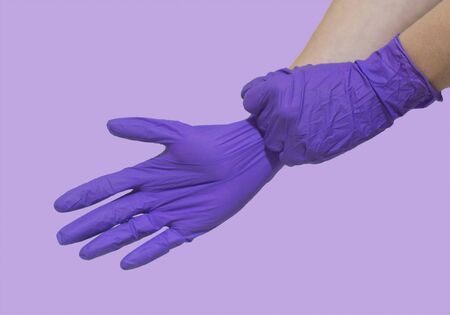 Hand in glove isolated over violet backgroundの写真素材