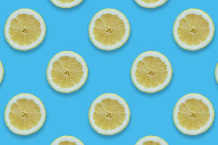 Pattern of fresh and juicy lemons on blue background. Tropical pictureの写真素材
