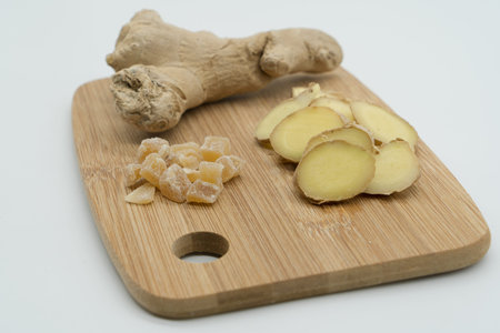 Cutting board of different types of Ginger. Raw ginger, sliced ginger and dehydrated ginger cubes on...