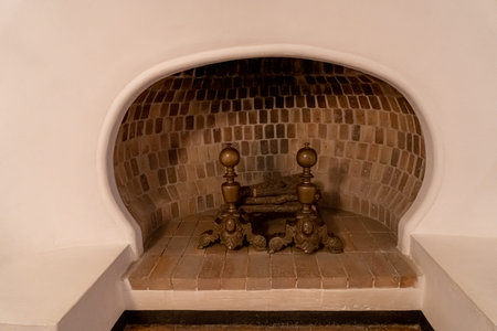A vertical shot of a fireplace in a stone wall with two candlesの写真素材