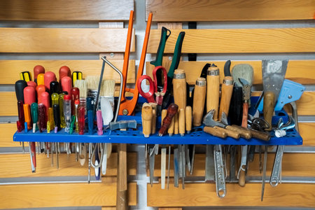 Set of different tools like pliers, wrenches, screwdrivers, tongs, etc, on a wooden board