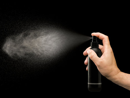 Spraying can hold by an handの写真素材