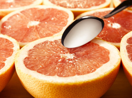 couple of delishes grapefruits with a spoonの写真素材