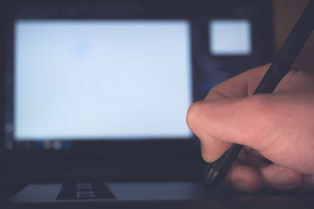 Close-up hand using graphic tablet at homeの写真素材