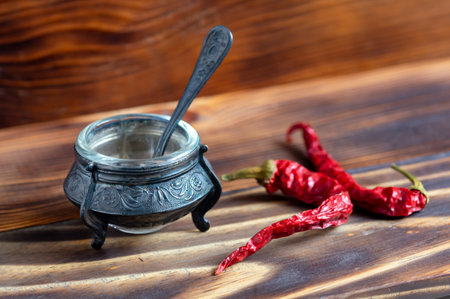Saltbox vintage isolated on a wooden background with a spoon. Red bitter pepperの写真素材