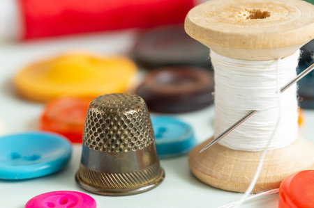 Sewing items - thimble, needle, measuring tape, spools of thread