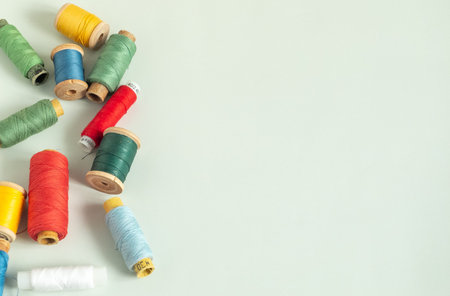 Background for sewing. Needlework supplies on a light background. Spools of thread, scissors,...