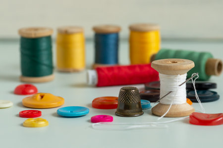 Sewing items - thimble, needle, measuring tape, spools of threadの写真素材