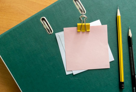 Blank note sticks on clip pencils and paper clips on document folderの写真素材