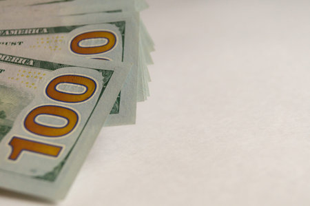 Close-up of $100 bills. On the right is a space for advertising text