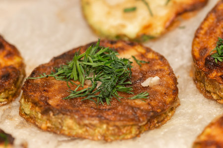 fried zucchini slices sprinkled with chopped parsleyの写真素材