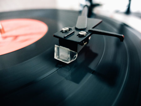 Close-up of a cartridge head on a vinyl record, analog retro music, vinyl disc collecting, vintage...