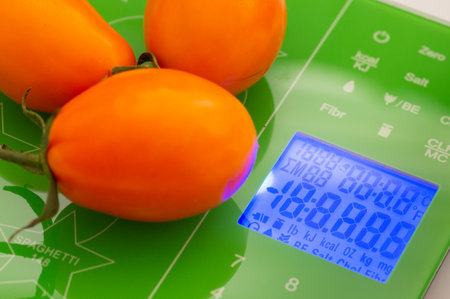 Orange tomatoes on the scalesの写真素材
