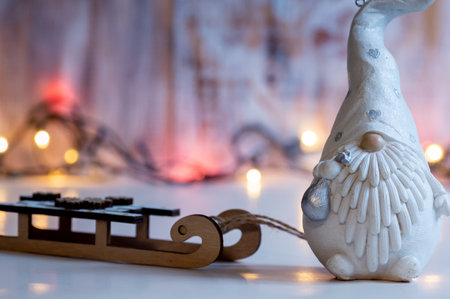 New Year figures of a sleigh and a gnome on the background of garlandの写真素材