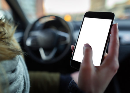 Hand using Smart phone at steering wheel. mock up image, blank screen isolated, checking internet...