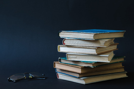 Open book, hardback hard cover colorful books with reading glasses on the side. Back to school. Copy space for text. Education, studying, learning, business conceptの写真素材