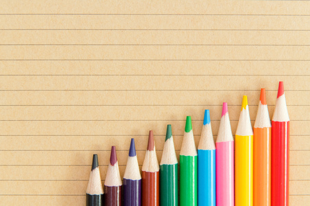 An assortment of colour pencils on notebook background. School supplies, creativity conceptの写真素材