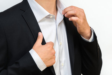 Closeup of businessman in formal suit correcting a shirt