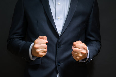 Business man fists clenched in anger. Annoying emotions at work