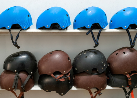 Blue, black and brown extreme sport helmets on the shelf with white backgroundの写真素材