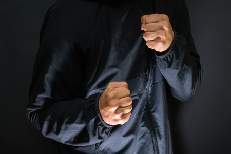 Violence and crime on the streets, digital glitch effect, victim is punched and mugged by aggressive violent man in hooded jacket, cctv security camera pov perspectiveの写真素材