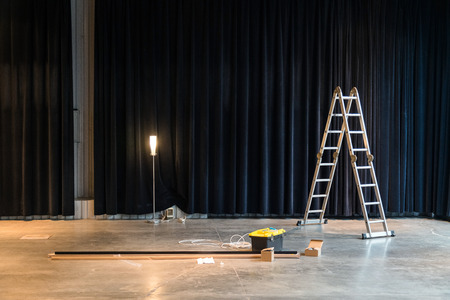 Construction in factory building or warehouse interior. Ladder, repairing tools, wires in concrete floorの写真素材