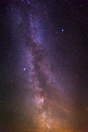Night landscape with colorful milky way stars and yellow light. Starry sky at autumn. Beautiful Universe. Space backgroundの写真素材