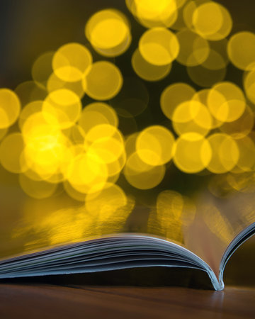 Open subscription magazine with blurry background. Holiday, Christmas bokeh balls. Copy space for...