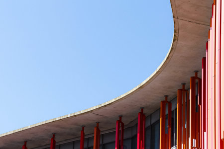 Detail of a modern architecture building with blue sky in the background. Curve of concrete roof...