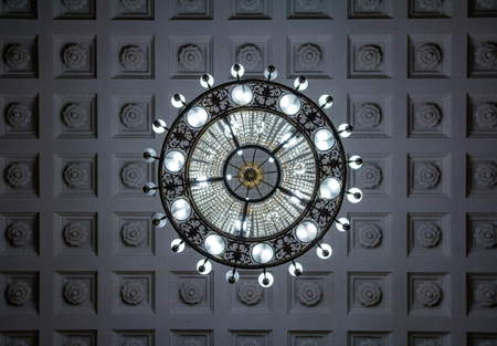 Looking up at crystal chandelier. Clean background. Richly theatrical chandelier in modern interior with modern energy saving lampsの写真素材